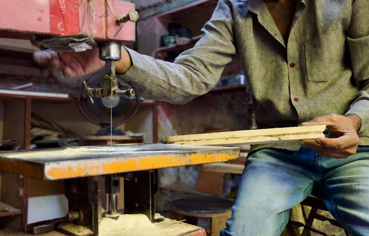 A carpenter cutting wood in his workshop
